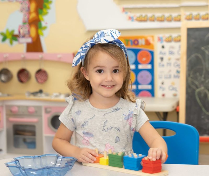 girl smile blocks Spanish Legacy Preschool